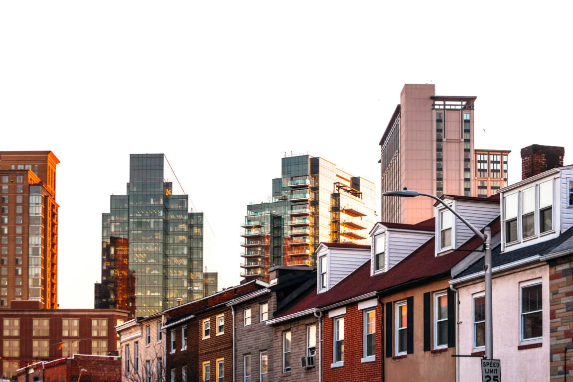 City skyline with modern and traditional buildings at sunset.