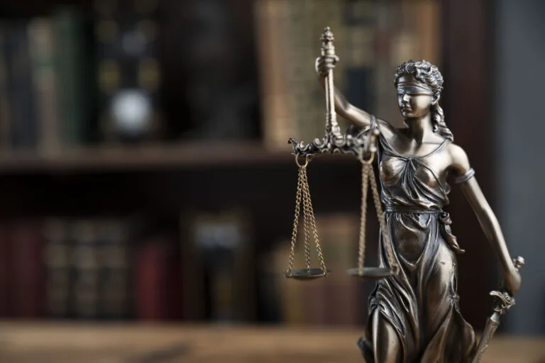 statue of justice holding scales in a courtroom
